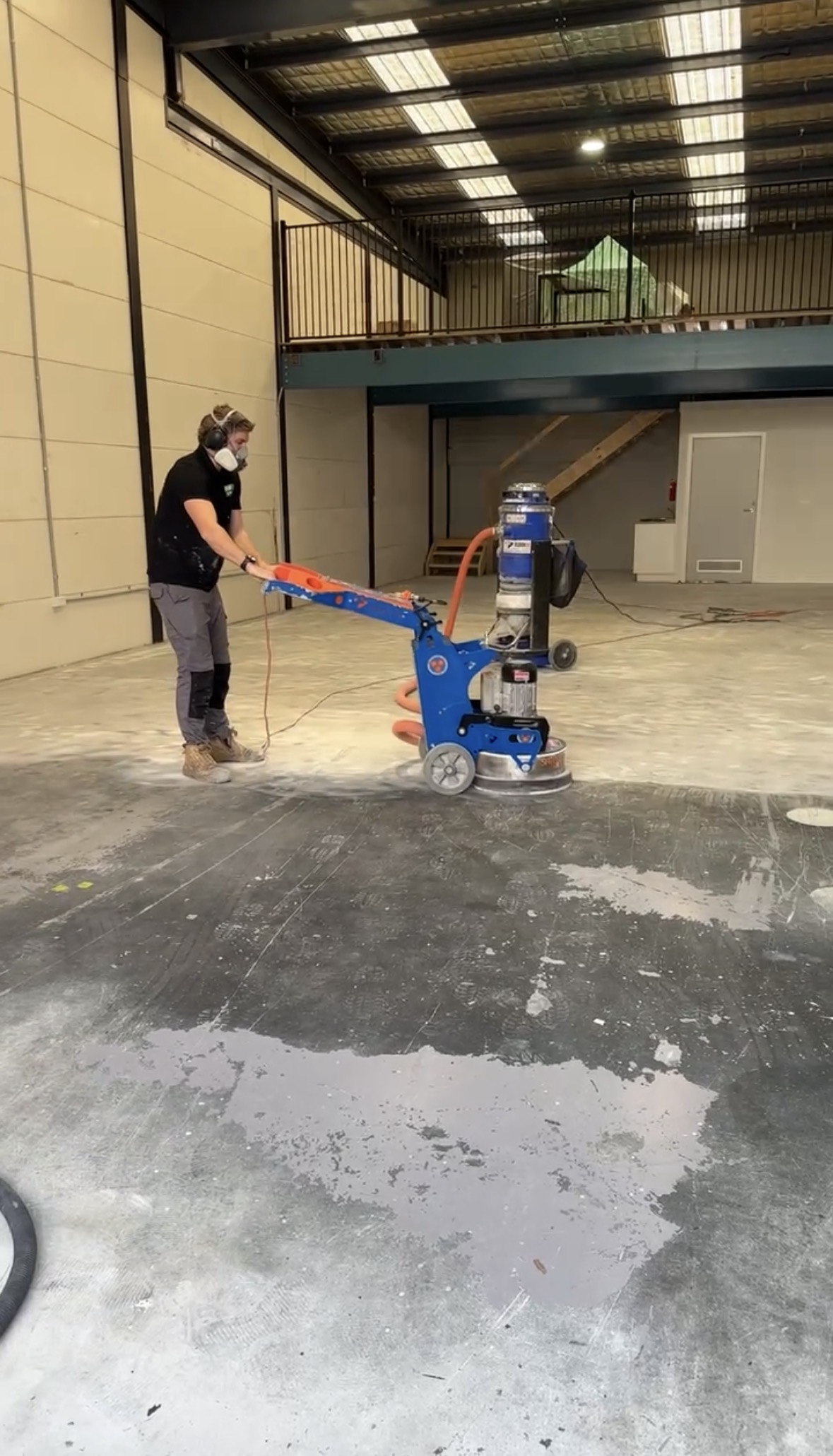 Concrete grinding in progress, industrial warehouse
